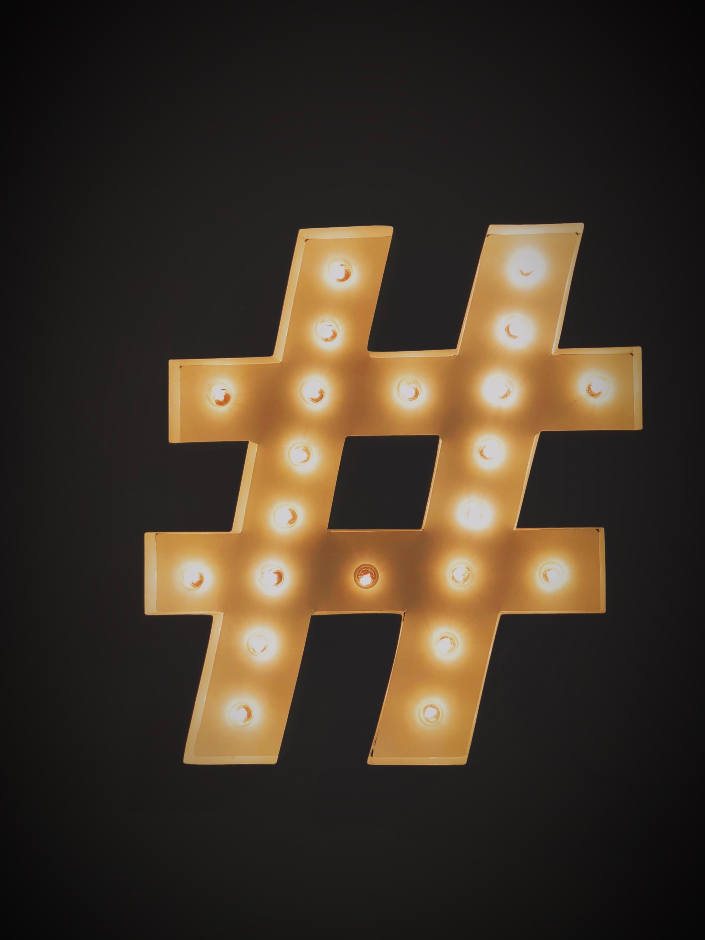 light bulbs illuminating a large hashtag sign