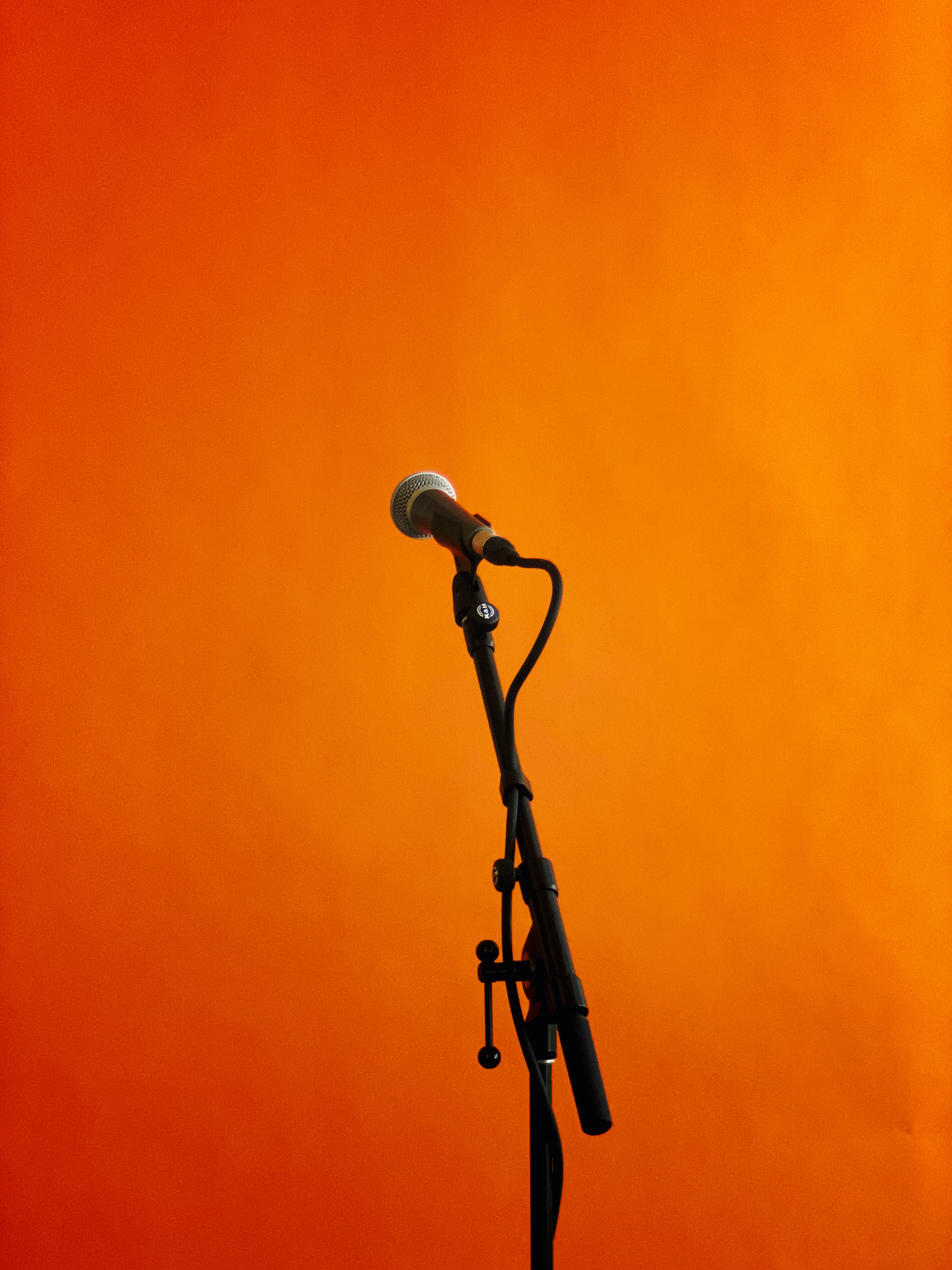 standing microphone in front of orange background
