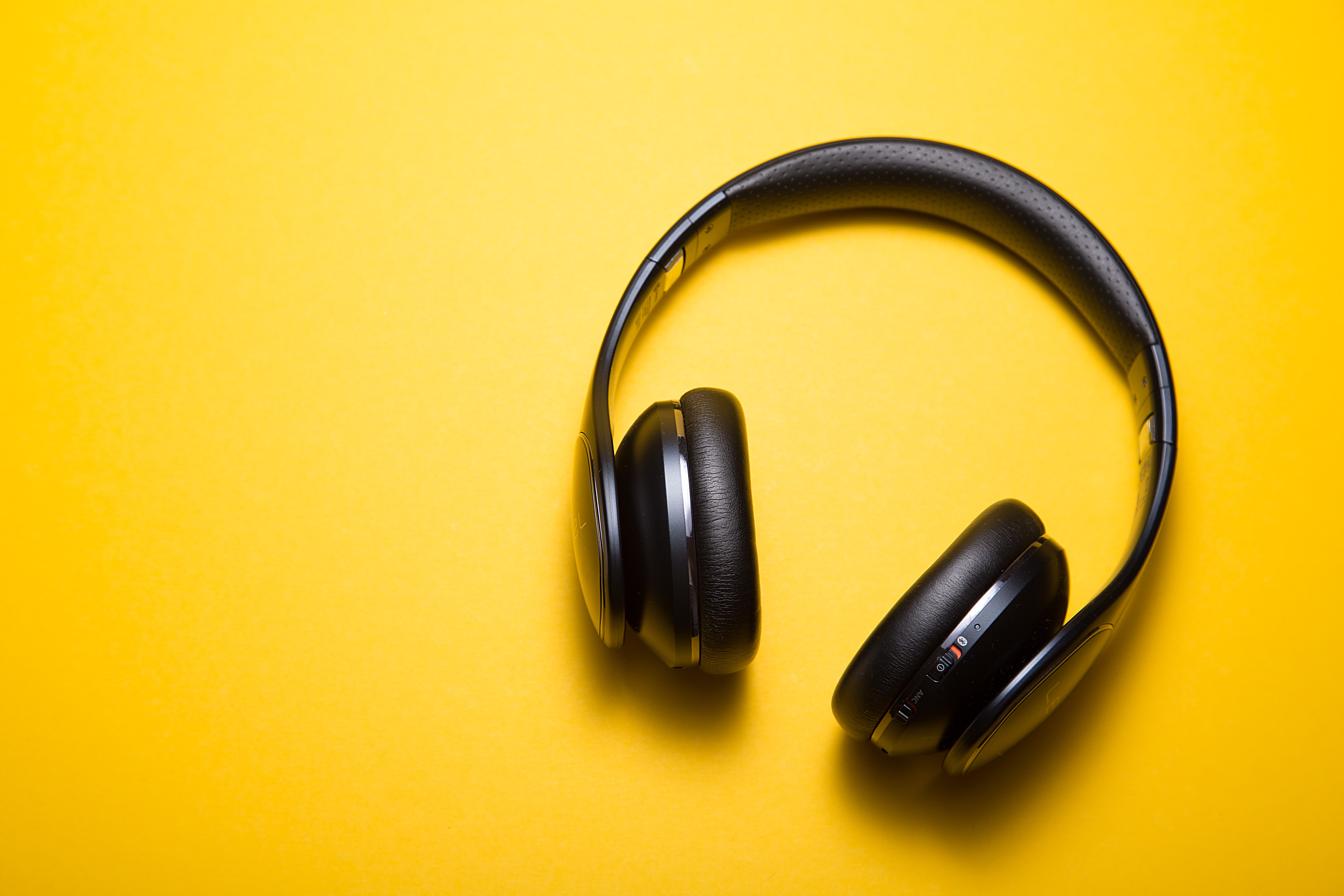 black over-ear headphones on yellow background